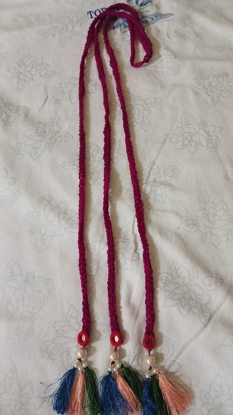 Handmade maroon rose knitted paranda with tassels by Graceful Crowns